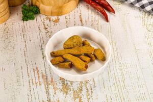 A bowl of food on a table with a knife and a pepper photo