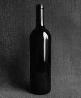 Classic black wine bottle against a textured background photo