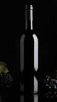 Classic wine bottle with dark grapes on a black background photo