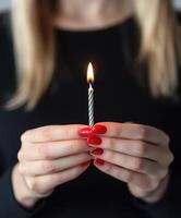 Celebrating with a lit candle held by a person photo