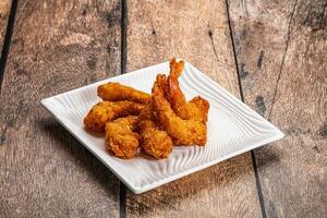 Fried shrimp on a white plate on a wooden table photo