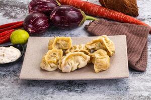 A plate with dumplings and vegetables on a table photo