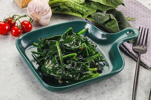 A green dish with spinach and tomatoes photo