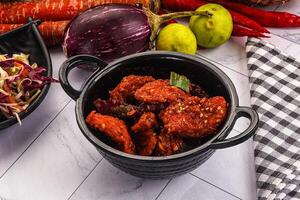 A bowl of food with vegetables and a black bowl with a black lid photo