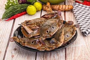 A plate of crabs on a table with other vegetables photo