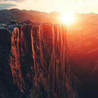 Sunrise over rocky cliff in mountain landscape photo