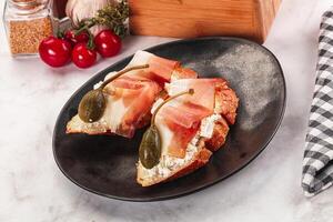 A plate with a sandwich on it and some tomatoes photo