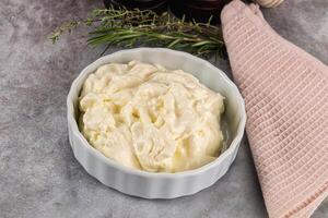 A bowl of cream with herbs and a towel photo