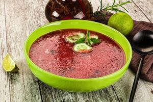 A bowl of soup with a spoon and a bottle of lemonade photo