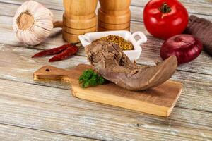 A meat on a cutting board with spices and vegetables photo