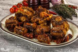 A plate of meat on a table with other ingredients photo
