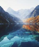 Mountain lake reflecting autumn colors at dawn photo