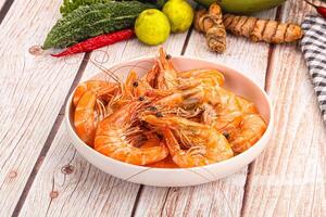 A bowl of shrimp and vegetables on a table photo