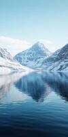 Mountain reflection in serene lake surrounded by snow photo