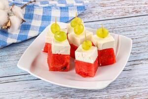 A plate of watermelon and cheese on a table photo
