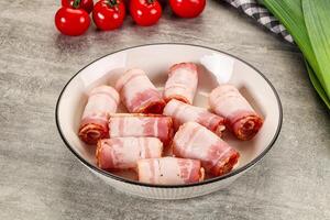 A bowl filled with bacon wrapped in bacon photo