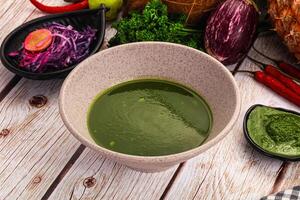 A bowl of green sauce with a pineapple on top photo