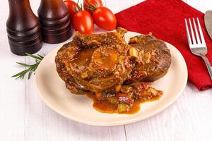 A plate of meat and vegetables on a table photo