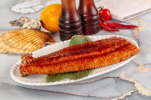 A plate with a fish on it and some other items photo
