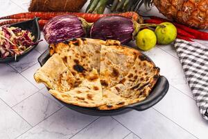 A bowl of food with a tortilla, vegetables and a pineapple photo
