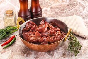 A bowl of meat and spices on a marble counter photo