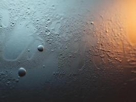 Water droplets on a surface with warm light reflections photo