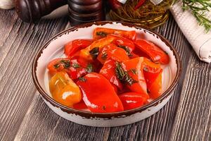 A bowl of peppers and herbs on a table photo