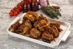 A white dish with meat and vegetables on it photo