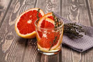 A glass of orange juice and a grapefruit on a table photo