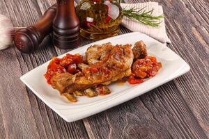 A plate of food with meat and vegetables on a wooden table photo