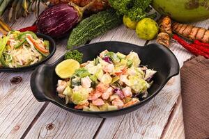 A table with two bowls of food and a plate of vegetables photo