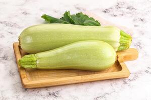 Two green squash on a cutting board photo