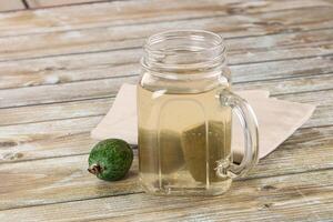 A glass jar with a lime and a napkin on a wooden table photo