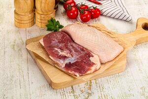 Raw meat on wooden cutting board with tomatoes and spices photo