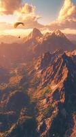 Paraglider flying over mountains at sunset photo