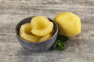 A bowl of peeled peaches and a bowl of sliced lemons photo