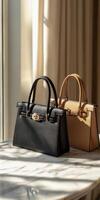 Two black and tan handbags sitting on a table photo