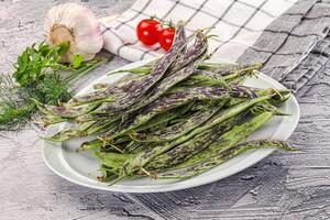 A plate of beans and vegetables on a table photo