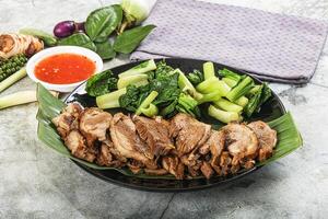 A plate of meat and vegetables on a table photo
