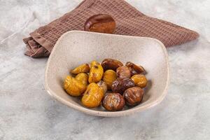 A bowl of dried dates and a towel on a table photo