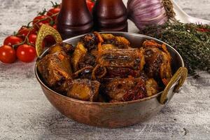 A bowl filled with meat and vegetables on a table photo