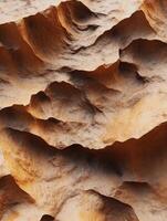 Textured landscape of natural rock formations in warm tones photo