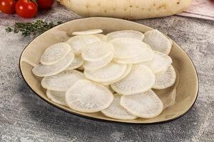 A bowl of sliced white radishes on a table photo
