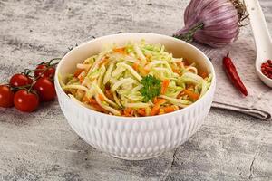 A bowl of coleslaw with tomatoes and onions photo