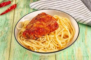 A bowl of pasta and a chicken leg photo