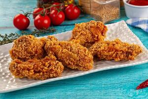 A plate of fried chicken on a blue table photo