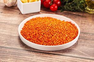 A bowl of red beans on a table next to a bowl of tomatoes photo