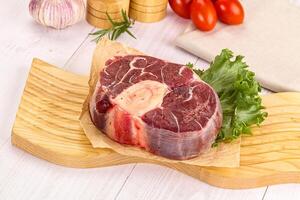 A piece of meat on a cutting board with vegetables photo