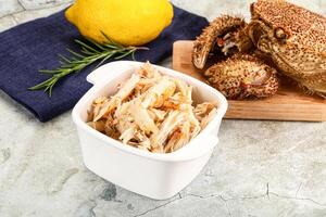Crab meat in a white bowl with lemon and rosemary photo