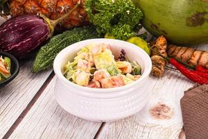 A bowl of salad with a coconut and a pineapple photo